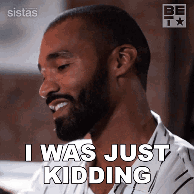 a man with a beard is smiling and saying i was just kidding