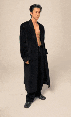 a shirtless man in a long black coat and pants