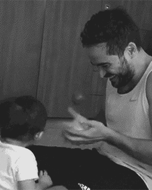 a man with a beard is playing with a baby .