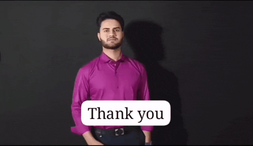a man in a purple shirt says thank you in sign language .
