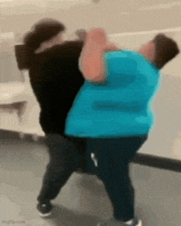 a blurry picture of two people fighting each other in a hallway .