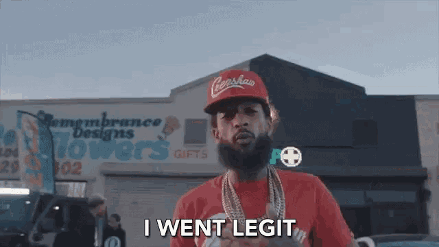 a man with a beard wearing a capshaw hat and a red shirt says i went legit