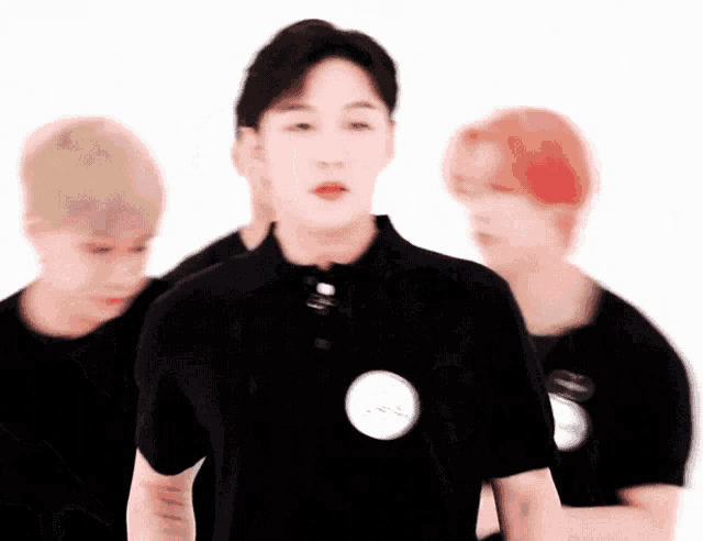 a man in a black polo shirt is standing in front of a group of people