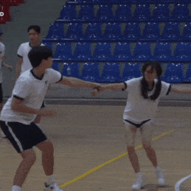 a man and a woman hugging on a basketball court in front of a group of people