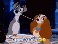 a couple of cartoon dogs are sitting at a table with a plate of food .