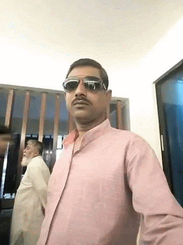 the man is wearing sunglasses and a pink shirt