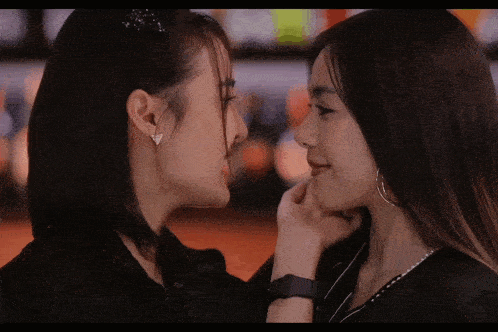 two women touching each other 's faces with their hands