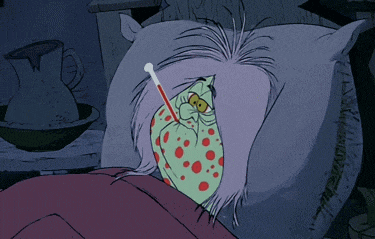 a cartoon character is laying in a bed with a thermometer in his mouth