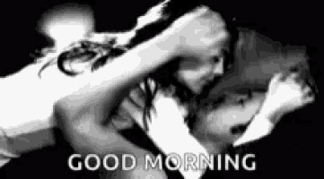 a black and white photo of a man and a woman hugging each other and the words `` good morning '' .
