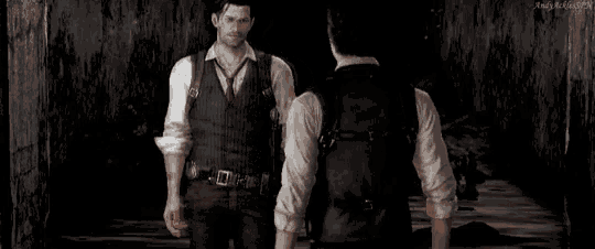 two men in suits are standing next to each other in a dark room .