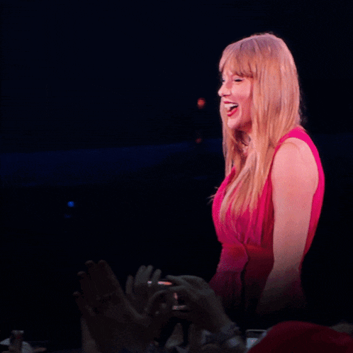 a woman in a red dress is covering her mouth with her hands