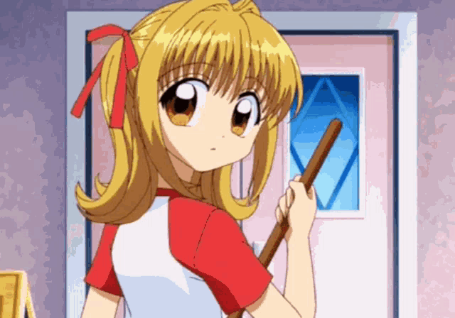 a girl in a red and white shirt is holding a mop in front of a door