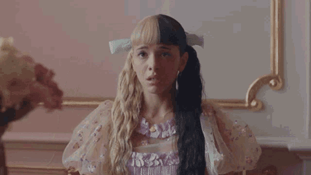 a woman in a pink dress is dancing in a room with her eyes closed .