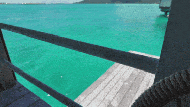 a view of the ocean from a dock with a rope railing