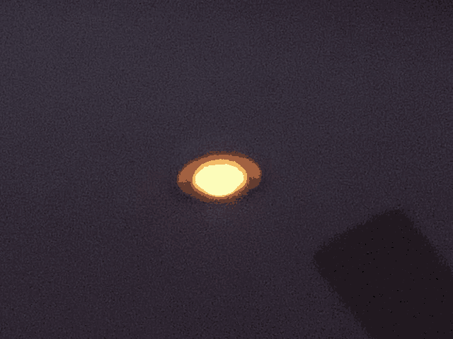 a yellow light is lit up in the dark sky