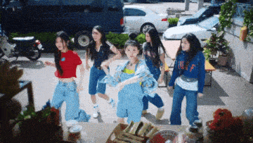 a group of girls are dancing in a parking lot and one of them is wearing a sweatshirt that says ' twice '