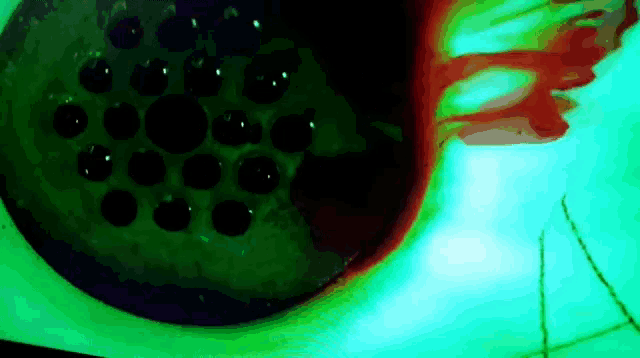 a close up of a green and red object with circles