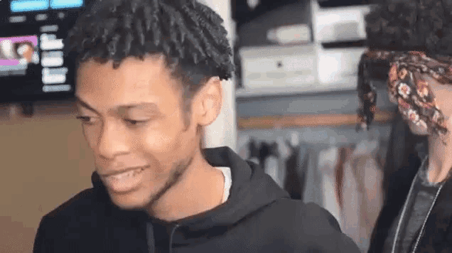 two young men are standing next to each other in a room .
