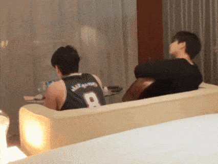 a man wearing a jersey with the number 8 is sitting on a couch