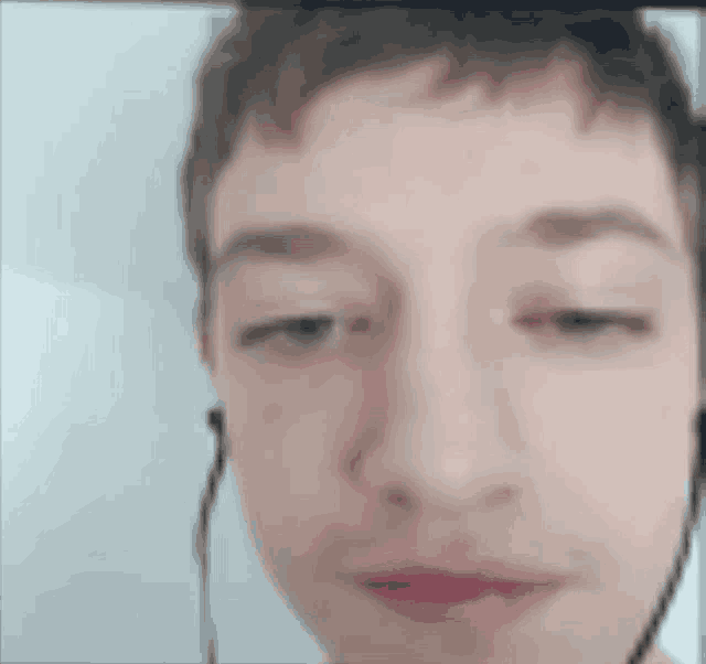 a close up of a person 's face with earbuds in their ears .