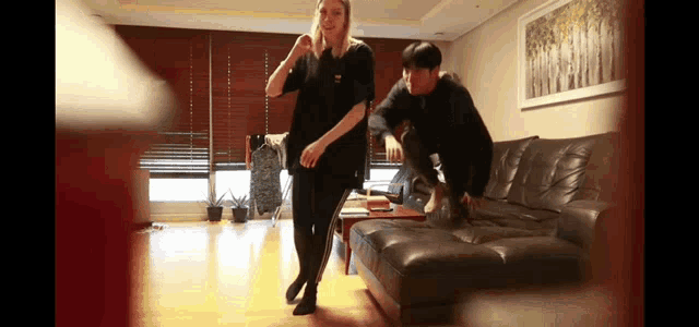 a man and a woman are dancing in a living room