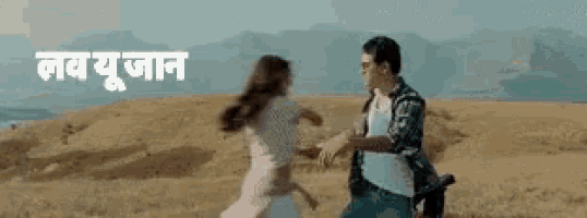 a man and a woman are running in a field with the words in a foreign language .