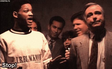 a group of people are standing around a man wearing a sweater that says l.b. blackman