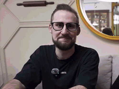 a man wearing glasses and a t-shirt that says elements