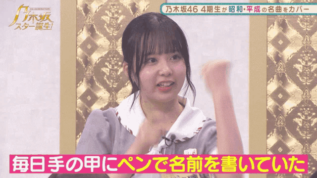 a girl with a fist in the air is on a screen with chinese writing on it
