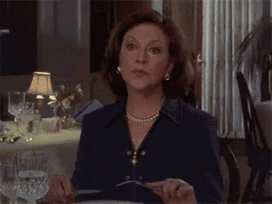 a woman is sitting at a table with a knife and fork in her hand