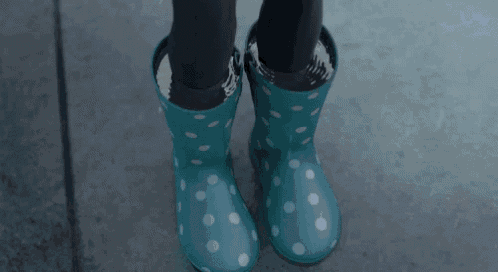 a person wearing blue polka dot rain boots