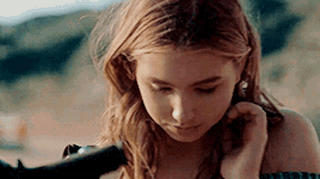 a close up of a woman 's face with her eyes closed and her hair in a braid .