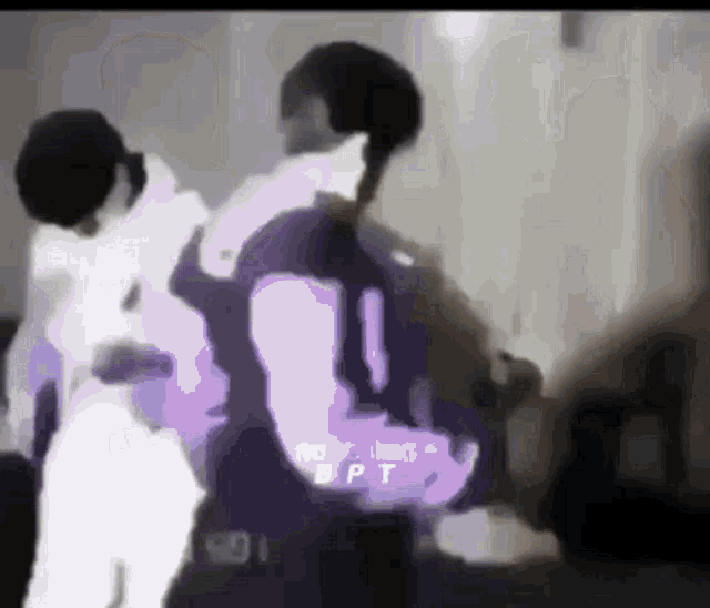 two men are standing next to each other in a room .