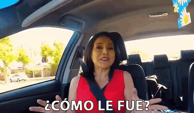 a woman in a red dress is sitting in a car and asking how it was