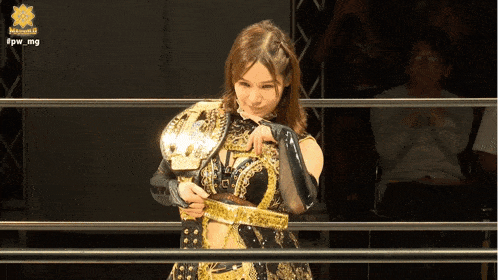a woman in a wrestling ring is wearing a belt that says nakamura