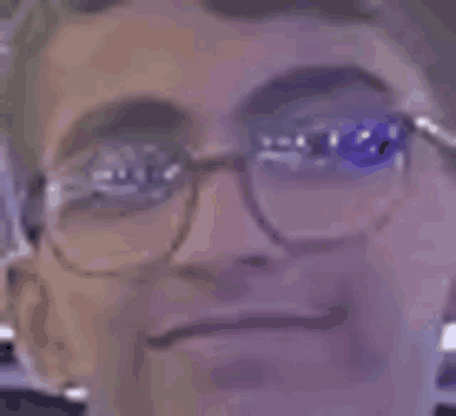 a close up of a man wearing glasses making a face .