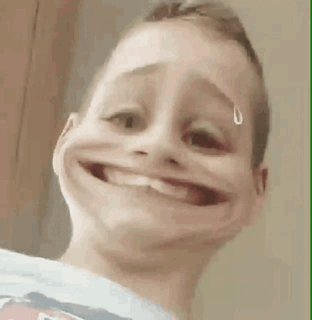 a young boy is making a funny face with a tear running down his forehead