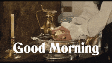 a man is washing his hands in a silver bowl with the words good morning written on the bottom