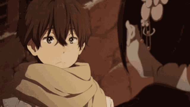 a boy with a scarf around his neck looks at a woman with earrings