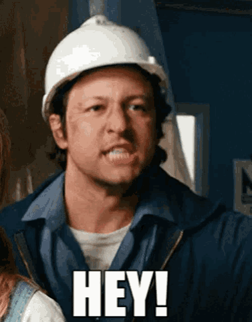 a man wearing a hard hat says " hey "