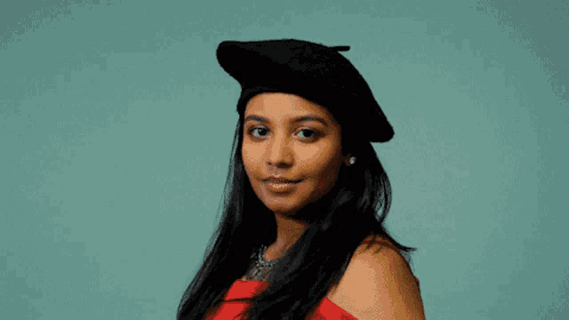 a woman wearing a red top and a black beret