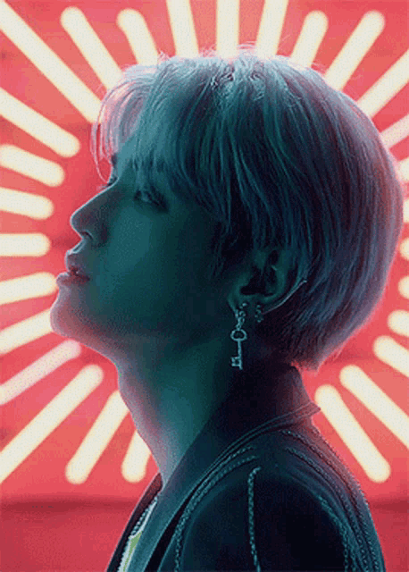 a close up of a person 's face with a red light behind him