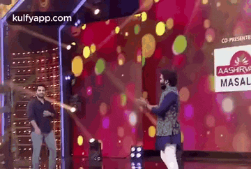 a man is dancing on a stage in front of a crowd .