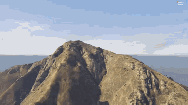 a screenshot of a video game shows a mountain with a blue sky behind it