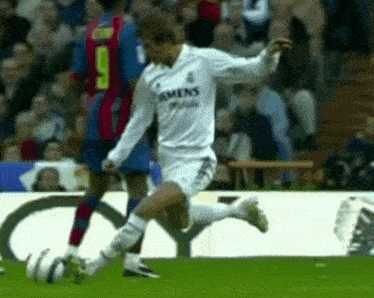 a soccer player wearing a white siemens jersey kicks the ball