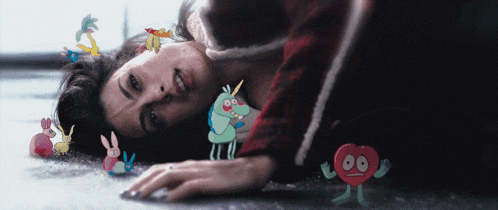a woman laying on the floor surrounded by cartoon characters
