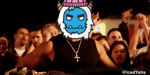 a man wearing a necklace with a cross stands in front of a crowd with a cartoon face on his head