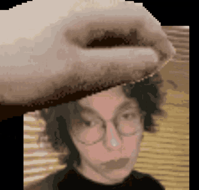 a pixelated image of a person 's face with glasses and a hand