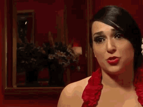 a woman is wearing a red dress and making a funny face .