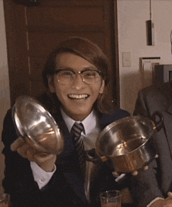 a man wearing glasses is smiling while holding a pot